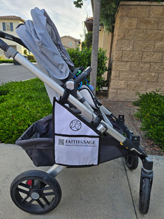 Stroller with a visible brand logo Faith & Sage on a sidewalk